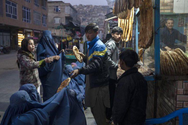 Seorang pria membagikan roti kepada warga Afghanistan di Kabul. Enam juta warga Afghanistan terancam kelaparan. 