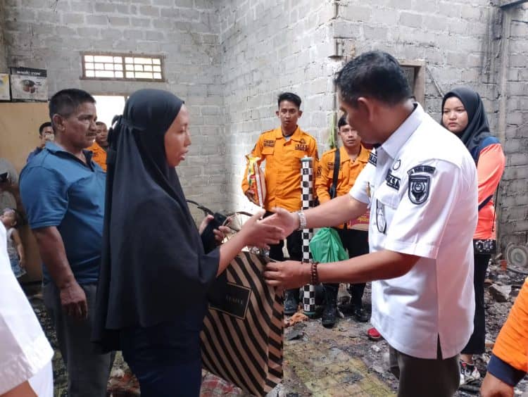 Kalaksa BPBD Kuansing saat menyerahkan bantuan kepada korban kebakaran rumah di seberang Taluk Hilir kecamatan Kuantan Tengah