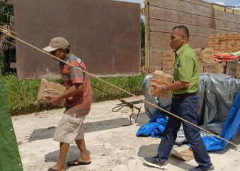 Penurunan bantuan logistik dari RAPP berupa paket bahan pokok untuk warga Pelalawan terdampak banjir.