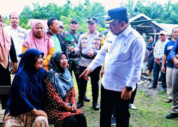 Wakil Bupati Siak Husni Merza asik bercengkrama bersama masyarakat di tempat pencoblosan suara kampung tambak rejo kelurahan sungai mempura.