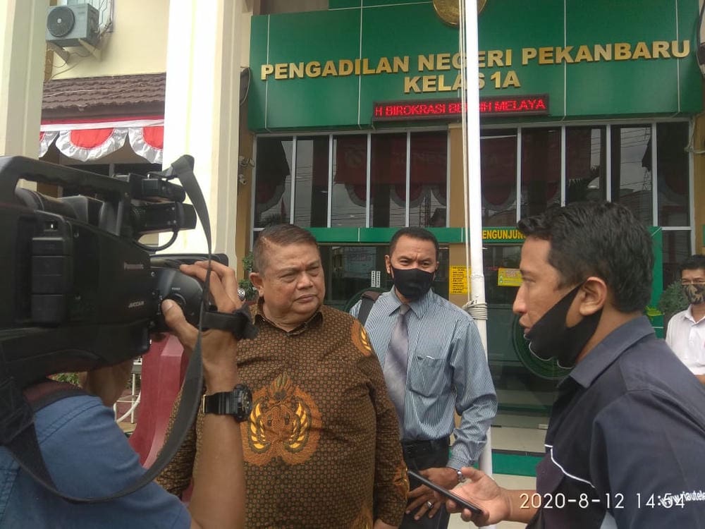 E. Sangur, SH, MH, mendampingi DR. Nudirman Munir SH, MH saat diwawancara wartawan usai sidang di PN Pekanbaru - Foto: Istimewa