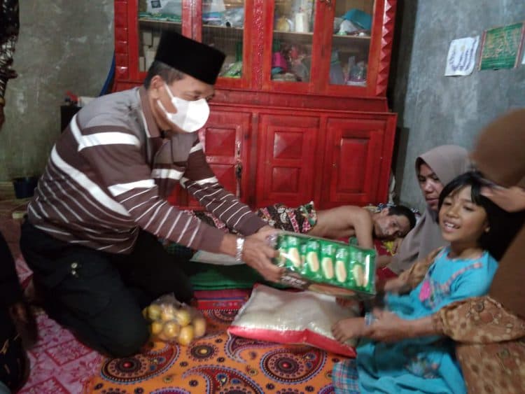 Irfendi Arbi memberikan makanan kepada anak Buyuang Kanten disaksikan istri dan Buyuang Kanten yang terbaring dengan posisi telungkup.