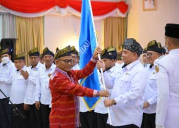 Ketua Umum PWI Pusat, H Atal S. Depari menyerahkan bendera pataka kepada Ketua PWI Provinsi Riau, H Zulmansyah Sekedang sebagai tanda dilantiknya kepengurusan PWI Provinsi Riau Periode 2022-2027