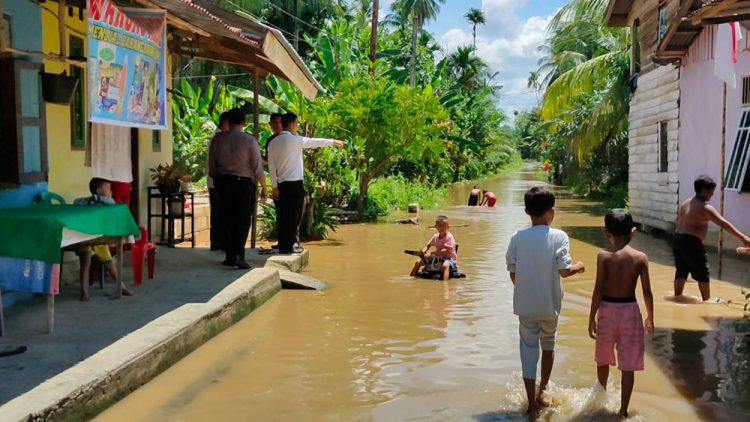 Kondisi jalan dan halaman rumah warga di Rohul yang sudah digenangi air luapn Sungai Batang Lubuh/FOTO: Istimewa.