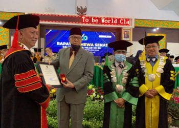 Rektor Universitas Islam Riau (UIR), Prof Dr Syafrinaldi, memberikan Pin emas dan piagam penghargaan kepada mantan Rektor UIR, Prof Tengku Dahril, dalam Rapat Senat Istimewa Peringatan Milad ke-60 UIR, di Ruang Auditorium, Gedung Rektorat, Senin (05/09/2022)