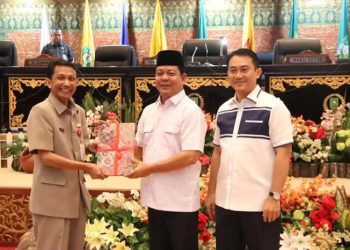 Wakil Ketua DPRD Riau Syafaruddin Poti didampingi Wakil Ketua DPRD Riau Hardianto menyerahkan naskah pandangan umum fraksi terhadap LKPJ Kepala Daerah kepada Pj Sekdaprov Riau Indra, Kamis (21/3/2024) (Humas DPRD Riau)