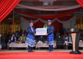 Sekdaprov Riau SF Hariyanto (kiri) menyerahkan hadiah untuk pemenang pacu jalur 2024. Hadiah diserahkan secara simbolis kepada Bupati Kuansing Suhardiman Amby, Rabu (21/8) di Lapangan Limono, Taluk Kuantan.