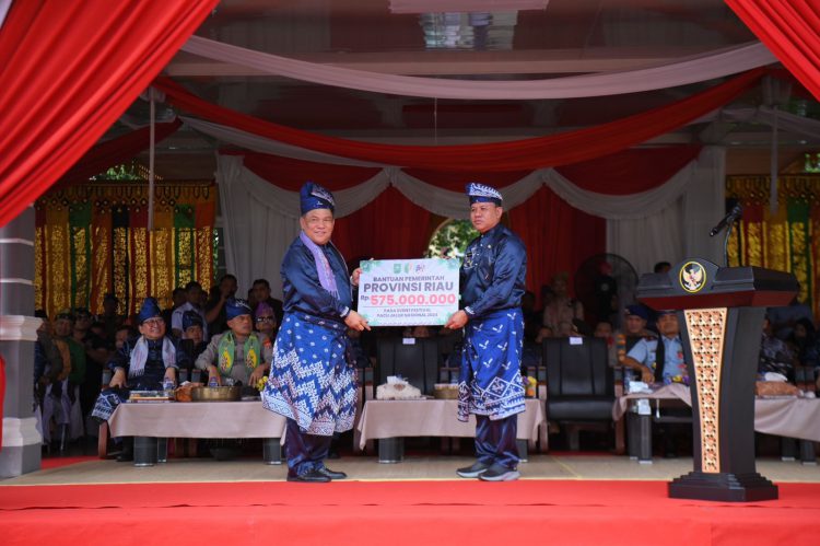 Sekdaprov Riau SF Hariyanto (kiri) menyerahkan hadiah untuk pemenang pacu jalur 2024. Hadiah diserahkan secara simbolis kepada Bupati Kuansing Suhardiman Amby, Rabu (21/8) di Lapangan Limono, Taluk Kuantan.