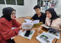 Rajab Vadil, Indah Amalia Ramadhan, dan Devti Marna Syafitri, berdiskusi di perpustakaan TPK Unri.