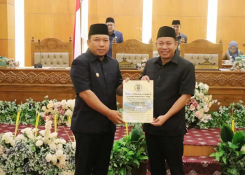 Ketua DPRD Siak Indra Gunawan menyerahkan hasil laporan Pansus BUMD kepada Wabup Siak Husni Merza di gedung paripurna Putri Kaca Mayang Kantor DPRD Siak. (SEKRETARIAT DPRD SIAK)