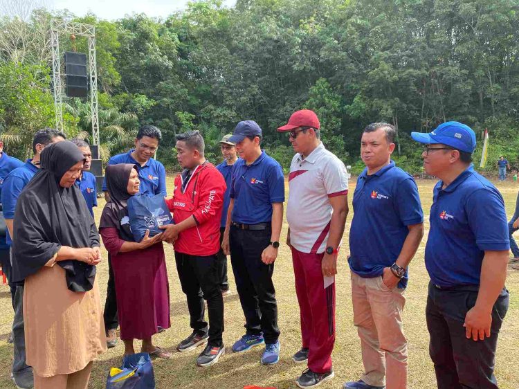 Bupati Pelalawan H Zukri didampingi COO RAPP Eduward Ginting menyerahkan bantuan paket Sembako kepada salah satu warga Desa Delik, Pelalawan dalam rangkaian kegiatan RGE Founder's Day 2024.