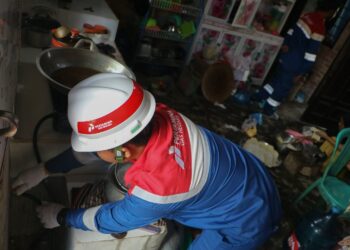 Riza Fahri, teknisi PT PGN Area Pekanbaru sedang memperbaiki bukaan penutup aliran bahan bakar (spuyer) di dapur rumah Sugiyem, Rabu, 3 September 2025, di di Gang 2000, Jalan Amirudin, Kelurahan Pangkalan Kerinci Timur, Pelalawan, Riau. Sugiyem merupakan salah seorang warga penerima manfaat program Jargas rumah tangga di daerah ini | Foto: Bertuahpos / Melba Ferry Fadly