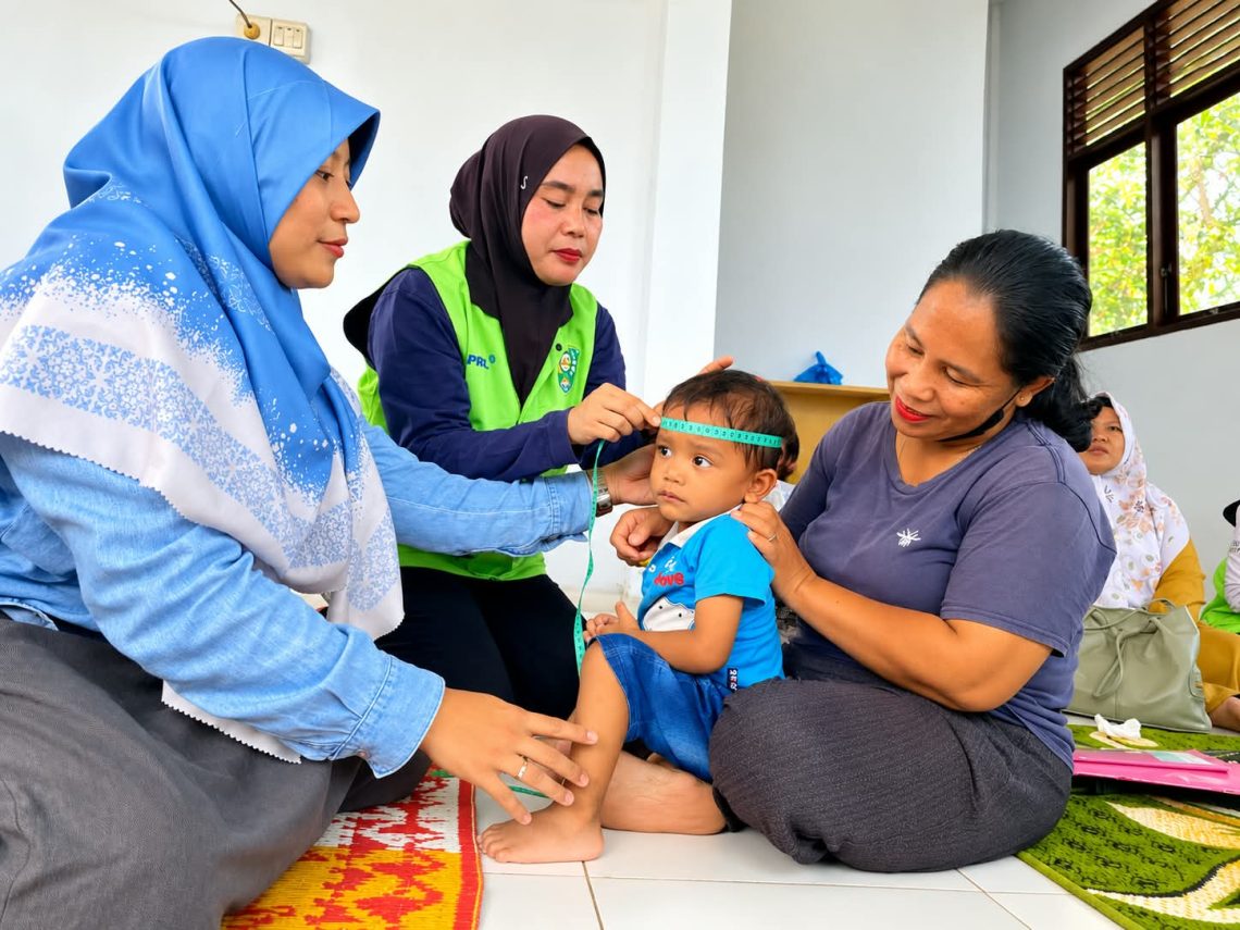 Pengukuran lingkar kepala oleh kader posyandu didampingi tim CD RAPP untuk memantau pertumbuhan dan perkembangan pada anak.